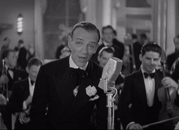 Movie still from “Swing Time” (1936), directed by George Stevens – A black - and - white photo of a man in a tuxedo; Medium shot, Low angle