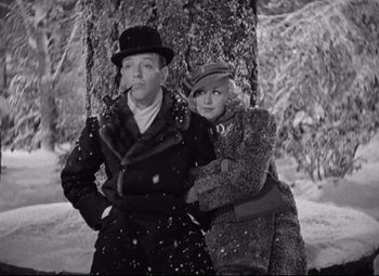 Movie still from “Swing Time” (1936), directed by George Stevens – A man and a woman standing next to each other in the snow; Medium shot, Low angle