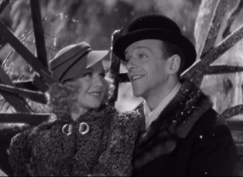 Movie still from “Swing Time” (1936), directed by George Stevens – A man and a woman standing next to each other under an umbrella; Close Up shot, High angle