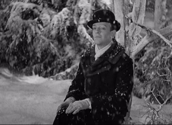 Movie still from “Swing Time” (1936), directed by George Stevens – An older man sitting in the snow next to a tree; Medium shot, High angle