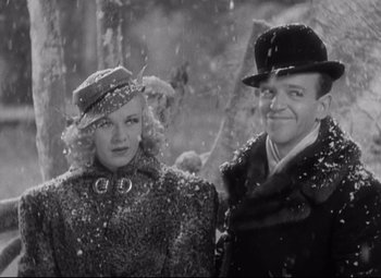 Movie still from “Swing Time” (1936), directed by George Stevens – A man and a woman standing next to each other in the snow; Medium shot, Low angle