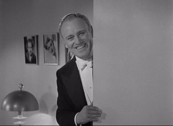 Movie still from “Swing Time” (1936), directed by George Stevens – A man in a tuxedo standing next to a wall; Medium shot, Low angle