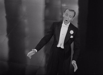 Movie still from “Swing Time” (1936), directed by George Stevens – A black and white photo of a man in a tuxedo; Medium shot, High angle