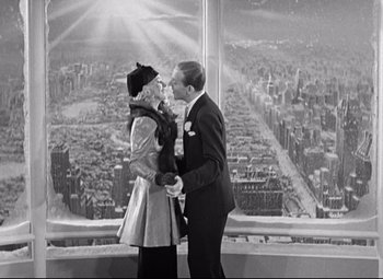 Movie still from “Swing Time” (1936), directed by George Stevens – A man and a woman kissing in front of an aerial view; Medium shot, High angle