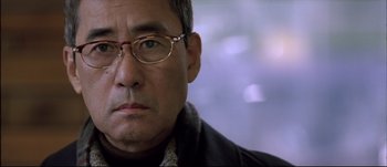 Movie still from “Sympathy for Lady Vengeance” (2005) – A person wearing glasses; Close Up shot, Over the shoulder angle