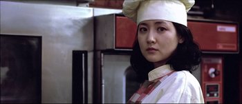 Movie still from “Sympathy for Lady Vengeance” (2005) – A woman wearing a chef's hat in a kitchen; Close Up shot, Low angle