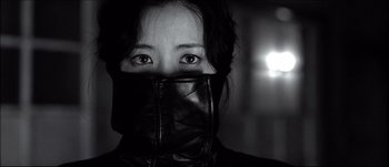Movie still from “Sympathy for Lady Vengeance” (2005) – A woman wearing a leather jacket covering her face; Close Up shot, Low angle
