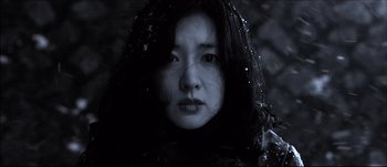 Movie still from “Sympathy for Lady Vengeance” (2005) – A woman with long black hair wearing a black jacket; Close Up shot, Low angle