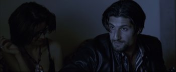 Movie still from “Syriana” (2005), directed by Stephen Gaghan – A man and a woman in a dark room; Close Up shot, Over the shoulder angle