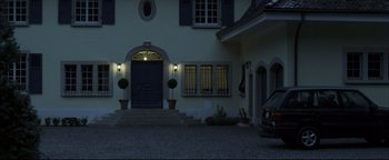 Movie still from “Syriana” (2005), directed by Stephen Gaghan – A car parked in front of a house at night; Extreme Wide shot, Low angle