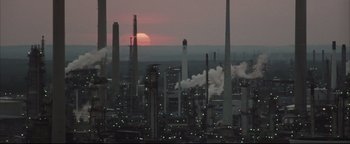 Movie still from “Syriana” (2005), directed by Stephen Gaghan – The sun is setting over a large oil refinery; Extreme Wide shot, Low angle