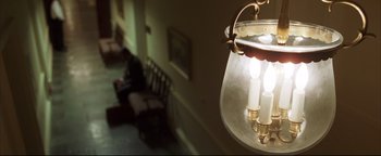 Movie still from “Syriana” (2005), directed by Stephen Gaghan – A lamp hanging from the ceiling in a room; Extreme Close Up shot, High angle