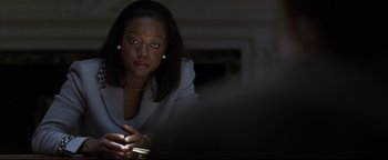 Movie still from “Syriana” (2005), directed by Stephen Gaghan – A woman looking at her cell phone in a dark room; Close Up shot, Over the shoulder angle