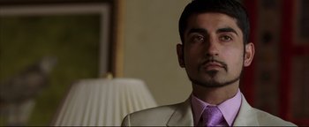 Movie still from “Syriana” (2005), directed by Stephen Gaghan – A person wearing a suit and tie; Close Up shot, Low angle