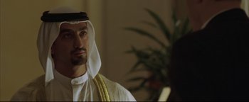 Movie still from “Syriana” (2005), directed by Stephen Gaghan – A person wearing a headdress; Close Up shot, Over the shoulder angle