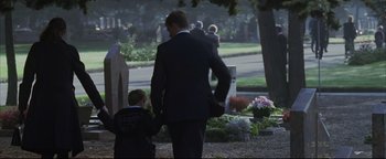 Movie still from “Syriana” (2005), directed by Stephen Gaghan – A man in a suit walking with a young boy; Wide shot, Over the shoulder angle