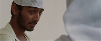 Movie still from “Syriana” (2005), directed by Stephen Gaghan – A person wearing a hat; Close Up shot, Over the shoulder angle