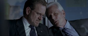 Movie still from “Syriana” (2005), directed by Stephen Gaghan – A couple of men sitting next to each other; Close Up shot, Low angle