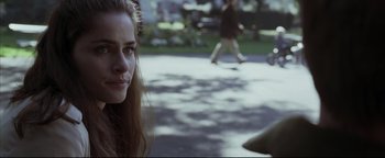 Movie still from “Syriana” (2005), directed by Stephen Gaghan – A woman sitting on the ground in front of a group of people; Close Up shot, Over the shoulder angle