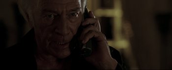 Movie still from “Syriana” (2005), directed by Stephen Gaghan – An older man talking on a cell phone; Close Up shot, Low angle