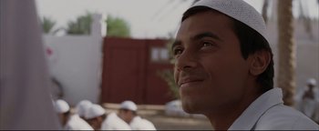 Movie still from “Syriana” (2005), directed by Stephen Gaghan – A person wearing a white hat; Close Up shot, Low angle