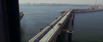 Movie still from “Syriana” (2005), directed by Stephen Gaghan – A bridge that is going over a body of water; Extreme Wide shot, High angle