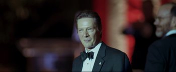 Movie still from “Syriana” (2005), directed by Stephen Gaghan – A man in a suit and bow tie; Close Up shot, Low angle