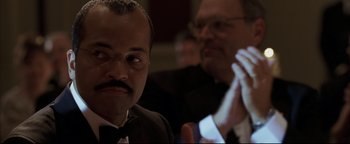 Movie still from “Syriana” (2005), directed by Stephen Gaghan – A man in a suit and tie with a mustache; Close Up shot, Low angle