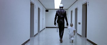 Movie still from “THX 1138” (1971), directed by George Lucas – A man and a child walking down a hallway; Wide shot, Low angle