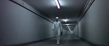 Movie still from “THX 1138” (1971), directed by George Lucas – A man in a white suit walking in a tunnel; Wide shot, Low angle