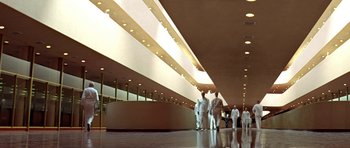 Movie still from “THX 1138” (1971), directed by George Lucas – A group of people standing in front of a building; Extreme Wide shot, Low angle