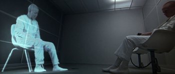 Movie still from “THX 1138” (1971), directed by George Lucas – A person in a room with a light shining on them; Wide shot, High angle