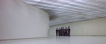 Movie still from “THX 1138” (1971), directed by George Lucas – A group of people standing inside of a building; Extreme Wide shot, High angle