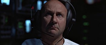 Movie still from “THX 1138” (1971), directed by George Lucas – A man with headphones on his head looking at the camera; Close Up shot, Low angle