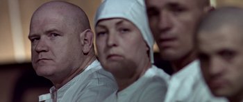 Movie still from “THX 1138” (1971), directed by George Lucas – A group of people wearing white clothing and hats; Close Up shot, Low angle