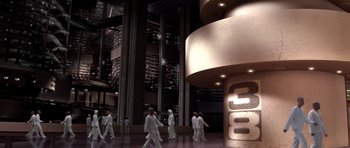 Movie still from “THX 1138” (1971), directed by George Lucas – A group of people walking around a building at night; Extreme Wide shot, High angle