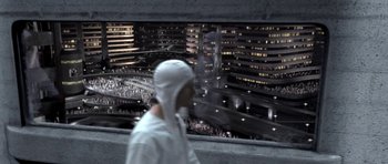 Movie still from “THX 1138” (1971), directed by George Lucas – A man in a white suit walking in front of a large city; Extreme Wide shot, High angle
