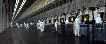 Movie still from “THX 1138” (1971), directed by George Lucas – A group of people in white lab coats and masks; Extreme Wide shot, High angle