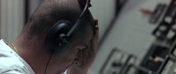 Movie still from “THX 1138” (1971), directed by George Lucas – A man with headphones is holding his head; Extreme Close Up shot, High angle