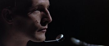 Movie still from “THX 1138” (1971), directed by George Lucas – A person holding a microphone; Close Up shot, Low angle