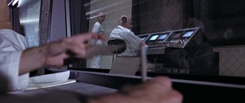 Movie still from “THX 1138” (1971), directed by George Lucas – Two men in white lab coats working in a lab; Medium shot, Over the shoulder angle