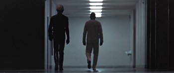 Movie still from “THX 1138” (1971), directed by George Lucas – Two men walking down a hallway in a building; Wide shot, Low angle