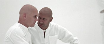 Movie still from “THX 1138” (1971), directed by George Lucas – A man with a bald head is looking at himself in the mirror; Close Up shot, Over the shoulder angle