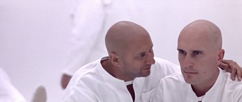 Movie still from “THX 1138” (1971), directed by George Lucas – A bald man in a white shirt is looking at the camera; Close Up shot, Over the shoulder angle