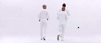 Movie still from “THX 1138” (1971), directed by George Lucas – A group of men in all white walking across a field; Wide shot, High angle