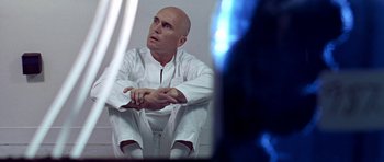 Movie still from “THX 1138” (1971), directed by George Lucas – A bald man sitting on the ground looking at himself in the mirror; Close Up shot, Low angle