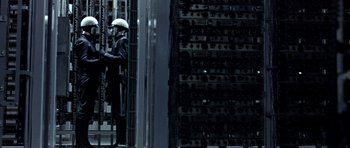 Movie still from “THX 1138” (1971), directed by George Lucas – A man in a white helmet standing in front of a rack of computers; Medium shot, Low angle