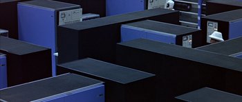 Movie still from “THX 1138” (1971), directed by George Lucas – A bunch of black and blue boxes in a dark room; Extreme Wide shot, High angle