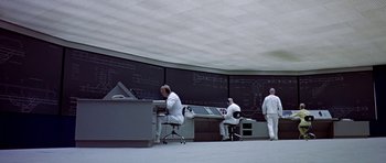 Movie still from “THX 1138” (1971), directed by George Lucas – A group of men in white lab coats working in a room; Wide shot, Low angle