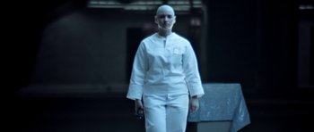 Movie still from “THX 1138” (1971), directed by George Lucas – A woman in a white outfit holding a gun; Medium shot, Low angle